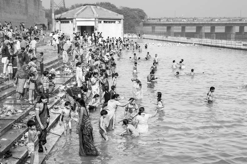 Challenges Impacting the Connection between Water and Religion - Devotees undertaking holy bath on the occasion of Kartik Purnima in an artificial water pool along river Yamuna in North district, Delhi